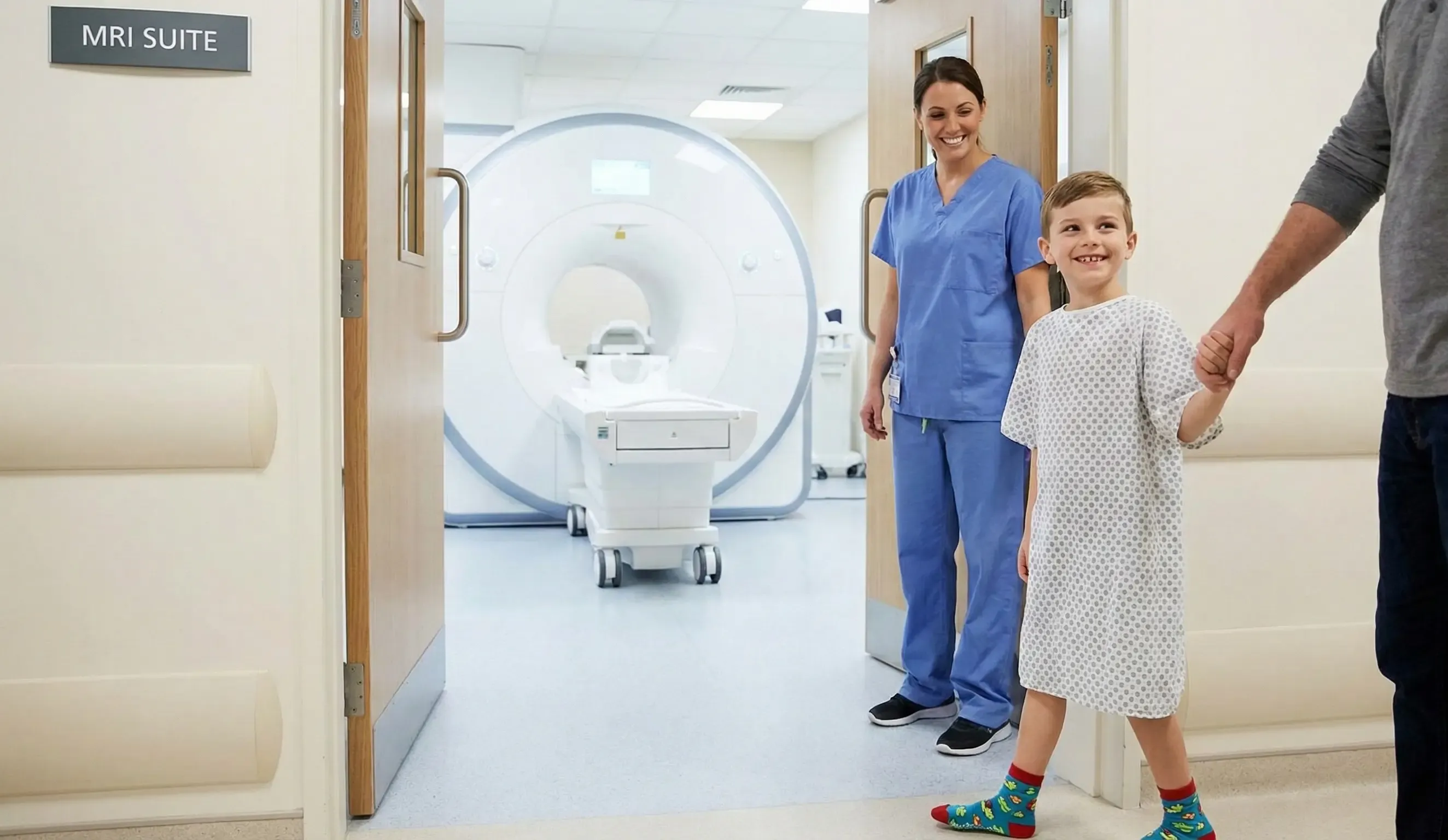 A child being guided into an MRI scanner while engaged by a calming point-of-care screen